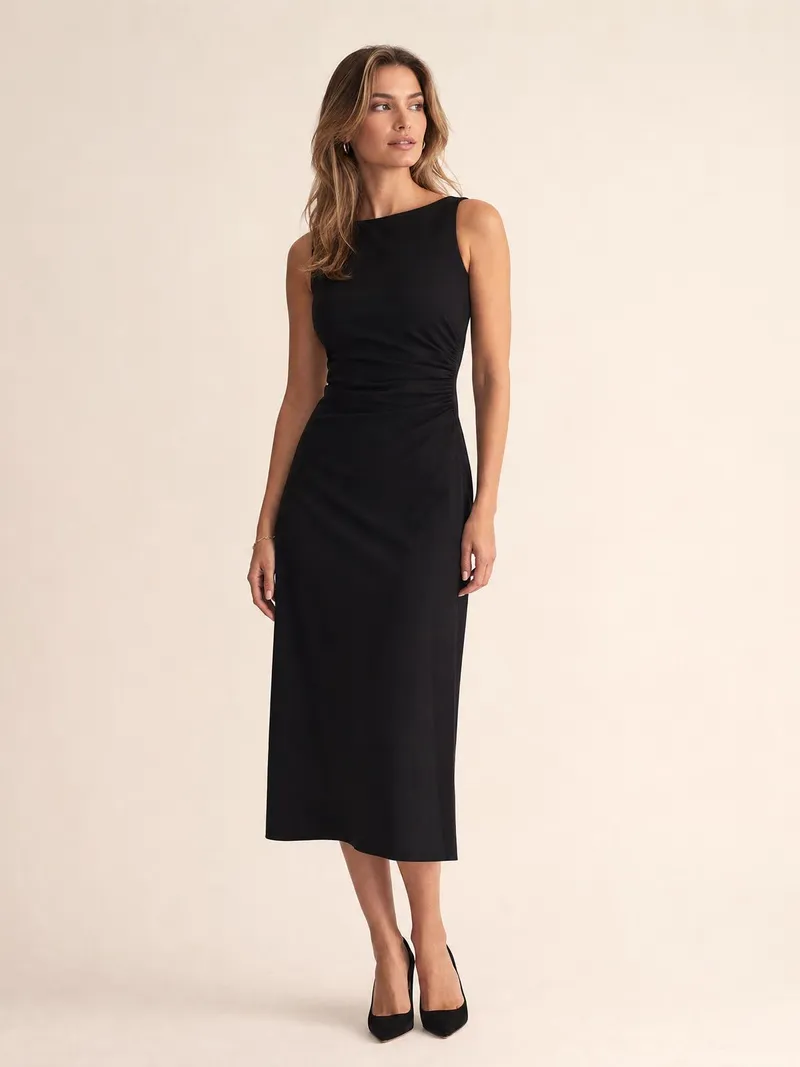 Frau in einem klassischen ärmellosen schwarzen Midikleid mit klaren Linien vor hellem Studiohintergrund
